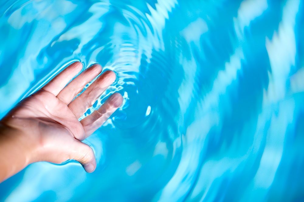 Child's Palm and blue clean crystal water